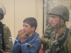 Jedno ze zatčených dětí odváděné do armádního džípu