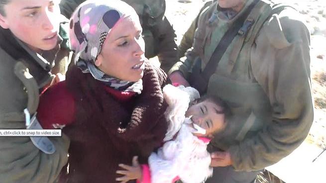  Izraelské okupační jednotky zatýkají nenásilně protestující Reemu a její 18měsíční dcerku Quamar v Umm Al Arayes, kopce jižního Hebronu (foto: Ta'ayyush)