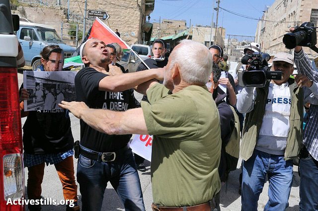 Izraelský osadník uhodil demonstranta při protestu v Hebronu proti plánované návštěvě prezidenta USA Baracka Obamy na Západním břehu Jordánu. Hebron, 20. března. (Foto activestills.org)